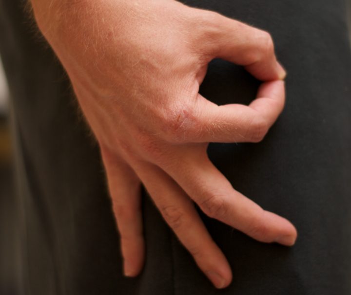 A hand making the circle gesture below the waist